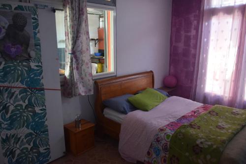 um pequeno quarto com uma cama e uma janela em Le Passager Cilaos em Cilaos