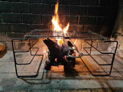 a fire in a brick oven with a grill at Casa Pescador Beach House in Struisbaai