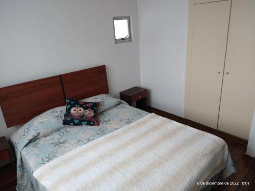 1 dormitorio con 1 cama con almohada de osito de peluche en Oportunidad! Depto a pasos del centro!, en La Serena