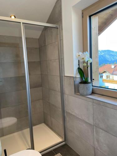 cabina de ducha con ventana y jarrón de flores en Schneiderhof en Weerberg
