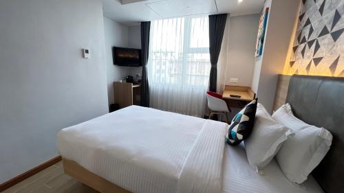 a hotel room with a bed and a desk at Aurora Boutique Hotel Imphal in Imphal
