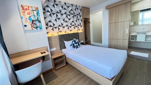 a small bedroom with a bed and a bathroom at Aurora Boutique Hotel Imphal in Imphal