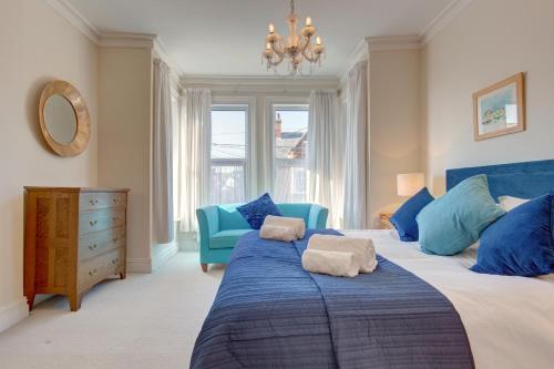 1 dormitorio con 1 cama azul y 1 silla azul en Fabulous Seaside Retreat, en Hunstanton