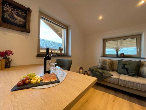 a room with a table with a bottle of wine and fruit on it at Schneiderhof in Weerberg