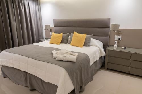 a bedroom with a large bed with yellow pillows at Hotel Metropol in San Miguel de Tucumán