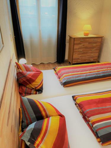 a bedroom with two beds with colorful pillows and a dresser at Appartement Valentin in Ehrwald