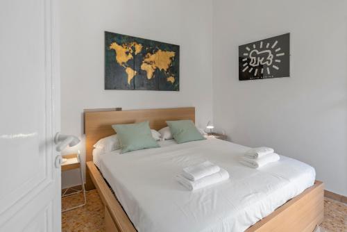 um quarto com uma cama com lençóis brancos e almofadas verdes em Urbana Rooftop em Roma