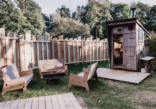 a backyard with two chairs and a wooden fence at destinature Dorf Südeifel in Ernzen