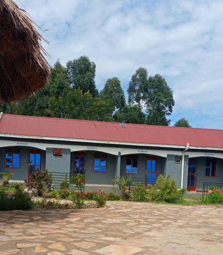 ein Gebäude mit blauen Fenstern und einem roten Dach in der Unterkunft Pross Residence in Masindi