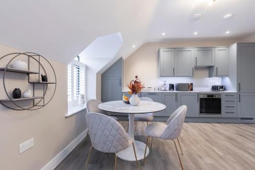 a kitchen and dining room with a table and chairs at Elliot Oliver - Stylish Loft Style Two Bedroom Apartment With Parking in Gloucester