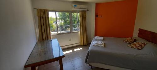 Habitación pequeña con cama y ventana en Céntrico Departamento Tangerine San Rafael en San Rafael