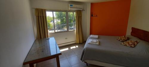 Un dormitorio pequeño con una cama y una ventana. en Céntrico Departamento Tangerine San Rafael, en San Rafael