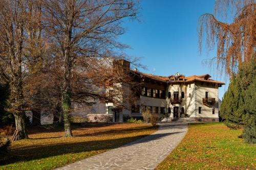 ein großes Steinhaus mit einem Weg davor in der Unterkunft B&B Villa Cavallier in Barzio