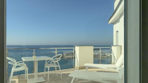 a balcony with a table and chairs and the ocean at Hotel Giosue' a mare Sorrento in Meta
