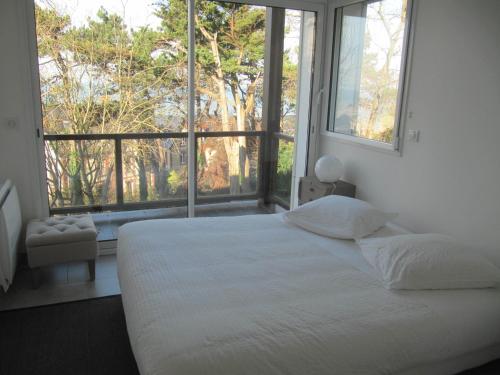 a bedroom with a white bed and a large window at La Regina in Trouville-sur-Mer