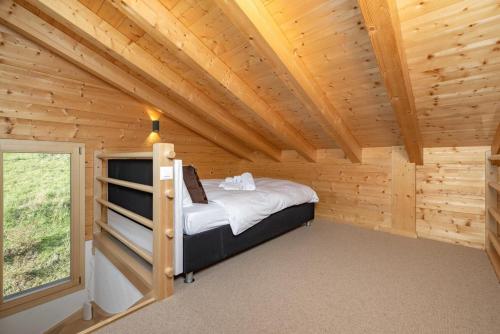 a log cabin with a bed in a room with a window at Chalet Amerhone - Luxury chalet With Jacuzzi in Riddes