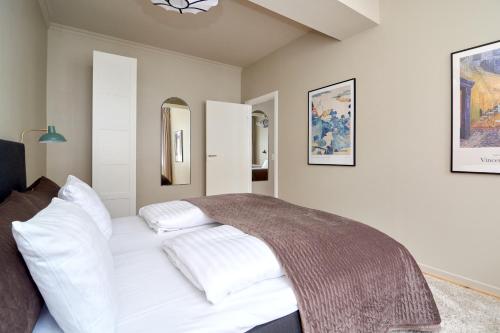 - une chambre avec un lit blanc et des oreillers blancs dans l'établissement Spacious 3B w Double Beds Copenhagen City Centre, à Copenhague