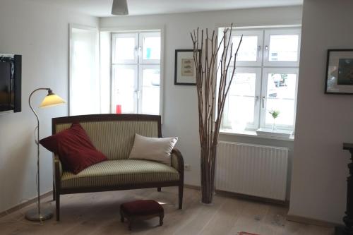 a living room with a chair and a tree at Wohnen am Dehnthof Haus 1 in Kappeln