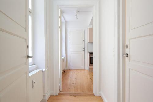 a hallway with white walls and a wooden floor at Spacious 3B w Double Beds Copenhagen City Centre in Copenhagen