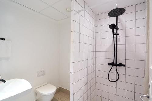 La salle de bains blanche est pourvue d'une douche et de toilettes. dans l'établissement Spacious 3B w Double Beds Copenhagen City Centre, à Copenhague