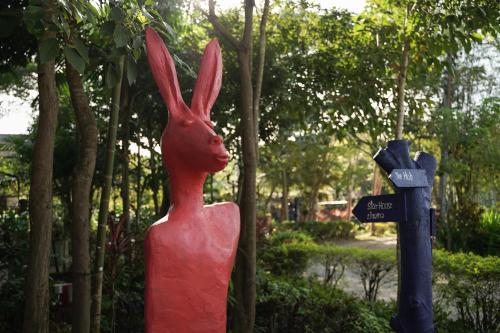 a red statue of a rabbit in a park at Art House at Chiangdao - Lake House in Chiang Dao