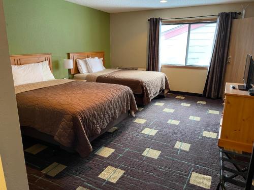 a hotel room with two beds and a window at Walker Hotel in Walker