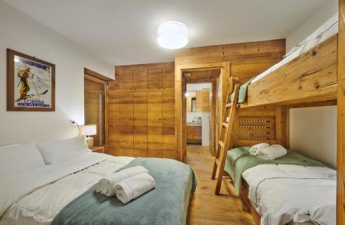 2 camas en un dormitorio con paredes de madera en The Wooden House Cortina, en Cortina dʼAmpezzo
