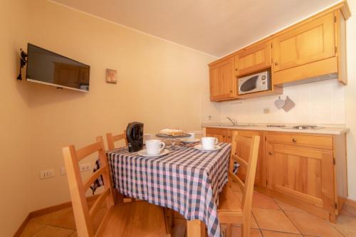 a small kitchen with a table with chairs and a microwave at Walsertal Residence in Gressoney-la-Trinité
