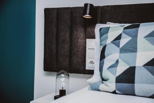 a bedroom with a bed with a pillow and a lamp at Casa de Couros in Guimarães