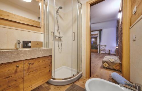 y baño con ducha y lavamanos. en The Wooden House Cortina, en Cortina dʼAmpezzo