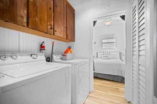 eine weiße Küche mit einem Waschbecken und einem Bett in der Unterkunft Calusa Cottage in Bradenton