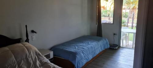 - une chambre avec un lit et une porte donnant sur une terrasse dans l'établissement Tindet, à Playa Hermosa