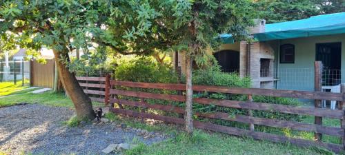 einen Zaun vor einem Haus mit einem Baum in der Unterkunft Tindet in Playa Hermosa