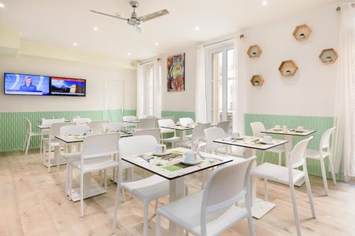 une salle à manger avec des tables et des chaises blanches dans l'établissement Hotel Florence Nice, à Nice