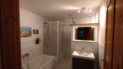 a bathroom with a tub and a shower and a sink at FeWo Strohbrück in Quarnbek