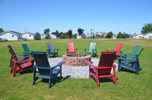 a group of colorful chairs sitting around a fire pit at Sundance Cottages in Cavendish