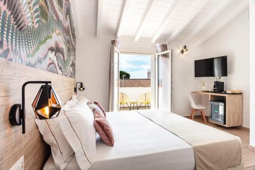 a bedroom with a large white bed and a balcony at Lungomare Rooms in Olbia