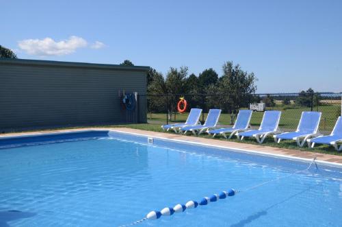 a swimming pool with lounge chairs and a swimming pool at Sundance Cottages in Cavendish