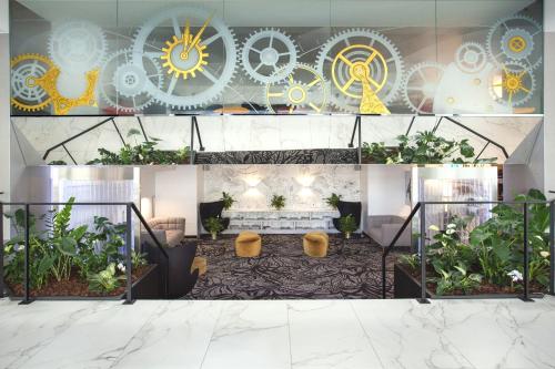 a lobby with plants and signs on the wall at Mercure Biel in Biel