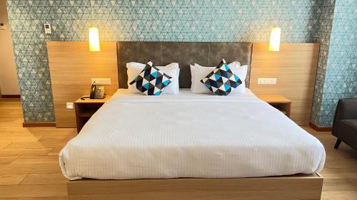 a bedroom with a large white bed with pillows at Aurora Boutique Hotel Imphal in Imphal