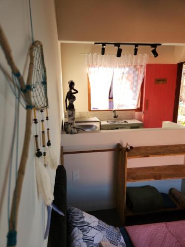 um pequeno quarto com uma cozinha e uma cama num quarto em Chalés Cabocla da Lua em Caraíva