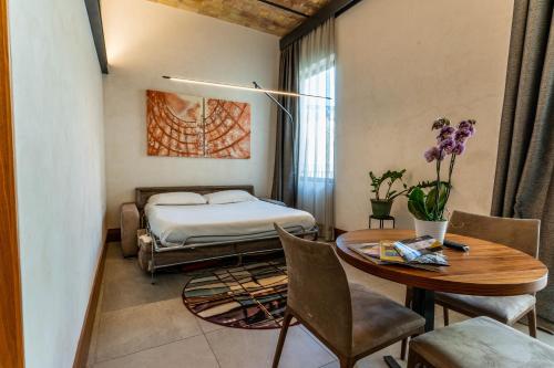 una camera con letto, tavolo e sedie di Gasometer Urban Suites a Roma