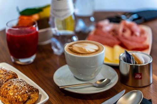 a table with a cup of coffee and a plate of food at Gasometer Urban Suites in Rome