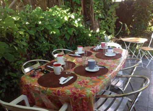 a table with chairs and a table with cups and plates at PARA TI GUESTHOUSE in Rio de Janeiro