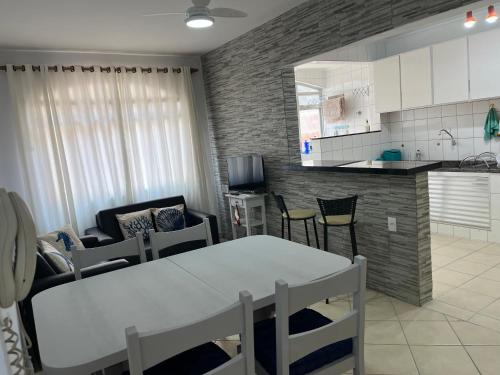een keuken en een woonkamer met een tafel en stoelen bij Apartamento 2 Guarujá enseada 2 dorm, 200m praia Ed Carpentier in Guarujá