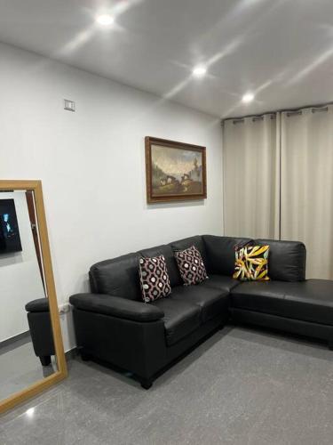 un sofá de cuero negro en la sala de estar en Apartamento en Ica 3, en Ica