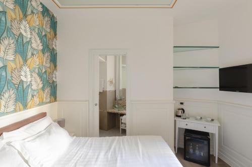 a white bedroom with a bed and a fireplace at Relais Roma Centro in Rome