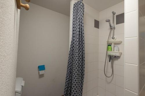 um chuveiro com uma cortina de chuveiro preto e branco na casa de banho em 12 mn Megeve studio confort em Flumet