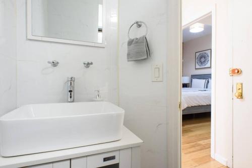 - une salle de bains blanche avec lavabo et une chambre dans l'établissement 428-4R prime midtown large 2 BR Newly Furnished, à New York