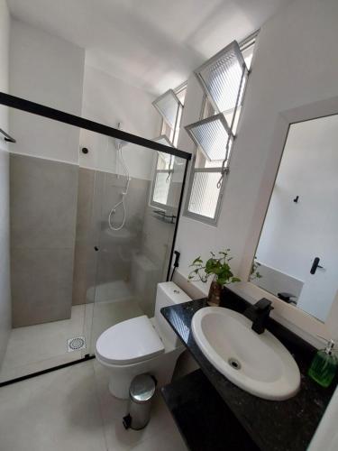 La salle de bains est pourvue d'un lavabo, de toilettes et d'une douche. dans l'établissement Próximo dos melhores hotéis do centro, 2 quartos, portaria 24h, à Florianópolis